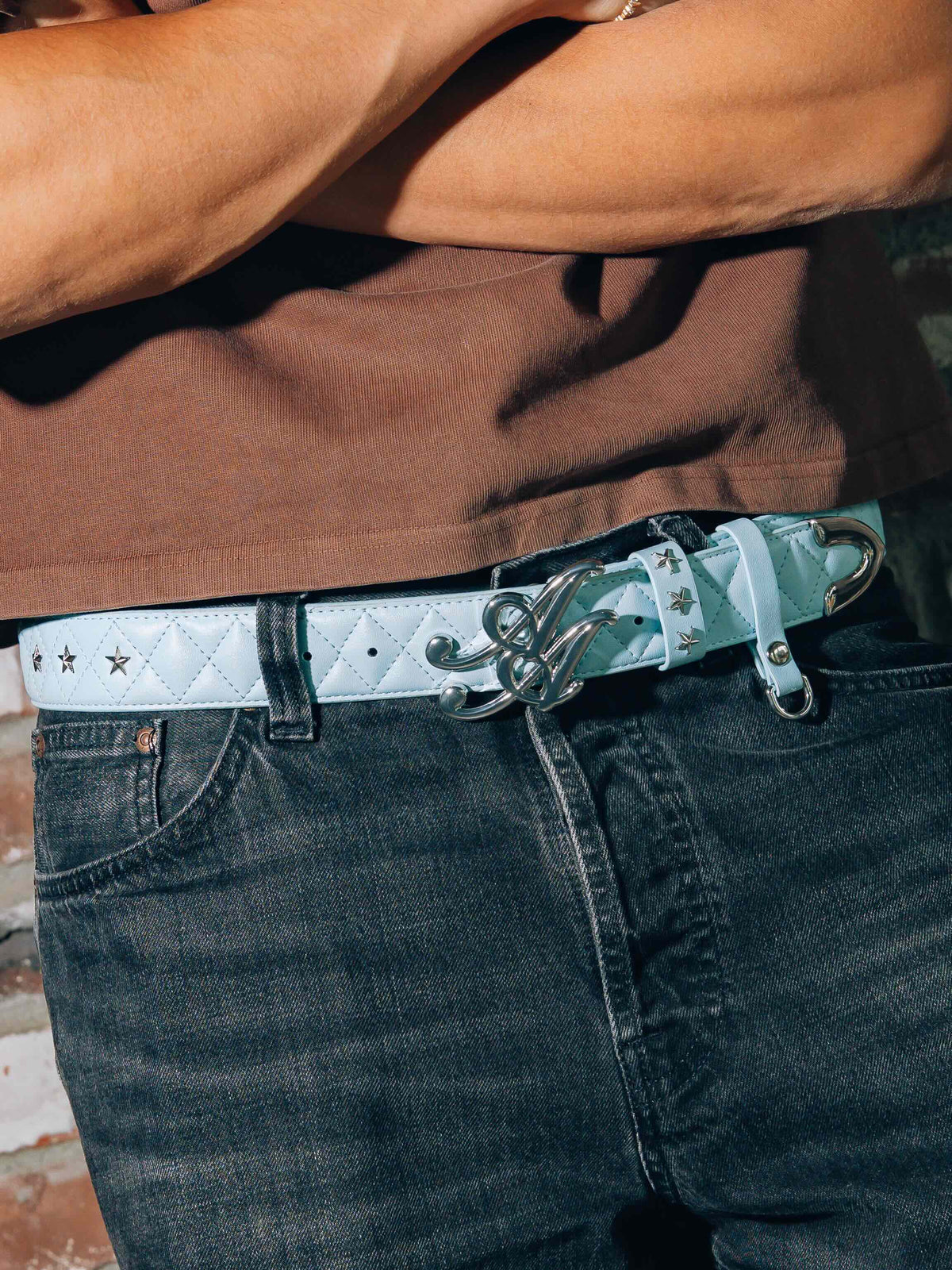 Ad Astra Marshal baby blue quilted belt with AA buckle worn with dark denim